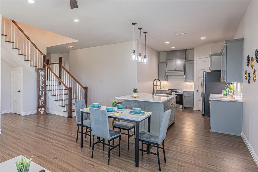 Dining area featuring recessed lighting, dark wood-style floors, and stairs Dining area featuring recessed lighting, dark wood-style floors, and stairs