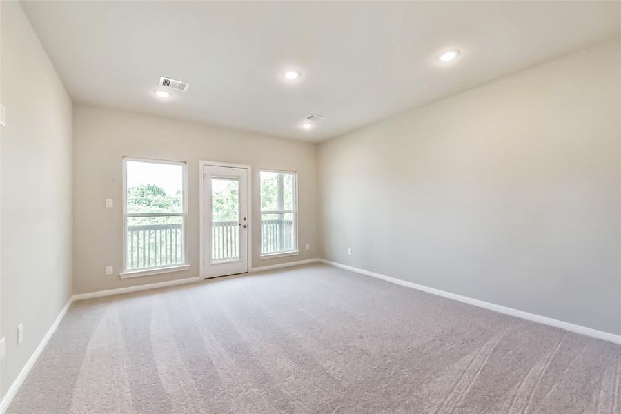 The primary bedroom is spacious, bright, and airy, featuring carpeted flooring and a door that opens to the balcony. The primary bedroom is spacious, bright, and airy, featuring carpeted flooring and a door that opens to the balcony.