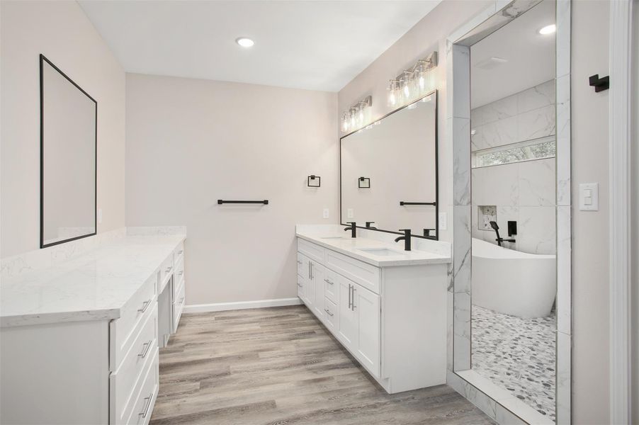 En suite bathroom with double vanity and a second countertop with tons of storage