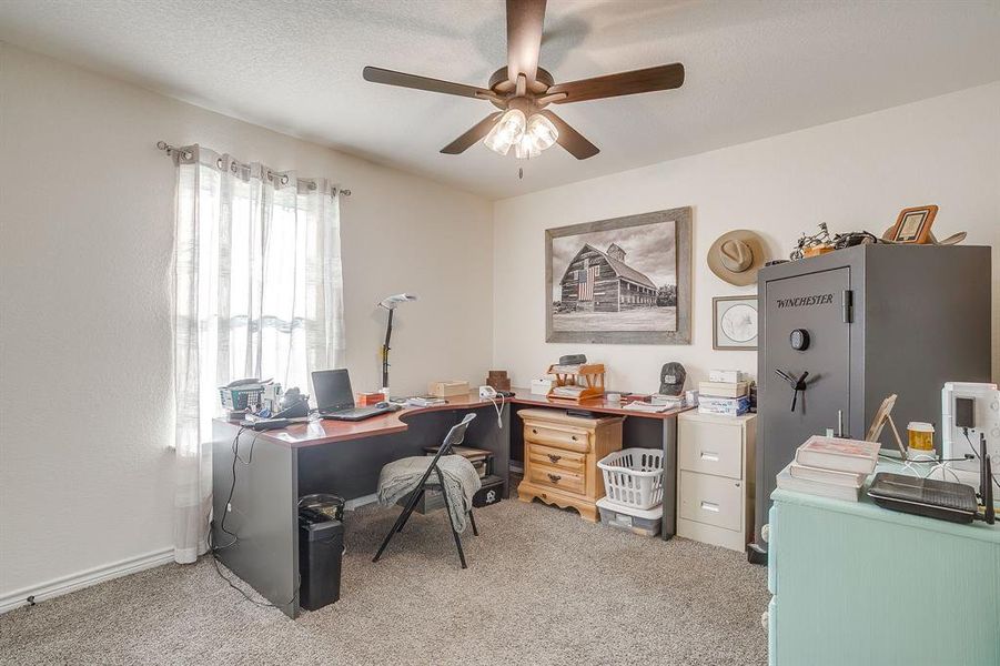 Bedroom being used as an office with light carpet, a ceiling fan, and a textured ceiling Bedroom being used as an office with light carpet, a ceiling fan, and a textured ceiling