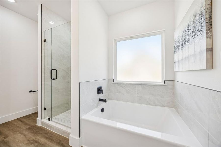 Soaking tub and separate shower in the ensuite primary bathroom