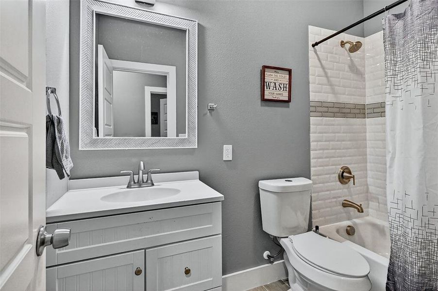 Full bath with a textured wall, shower / bath combination with curtain, and vanity Full bath with a textured wall, shower / bath combination with curtain, and vanity