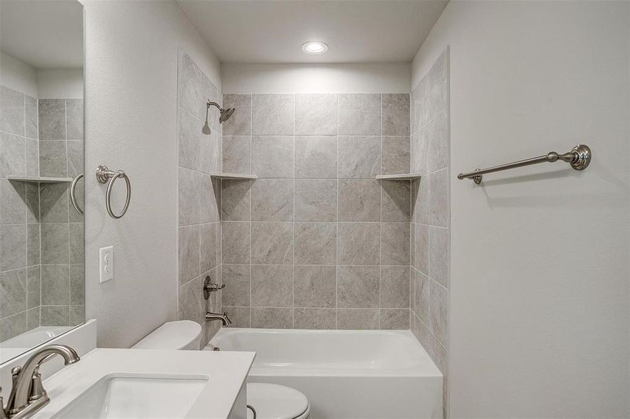 Full bathroom featuring vanity, shower / bathtub combination, and a textured wall
