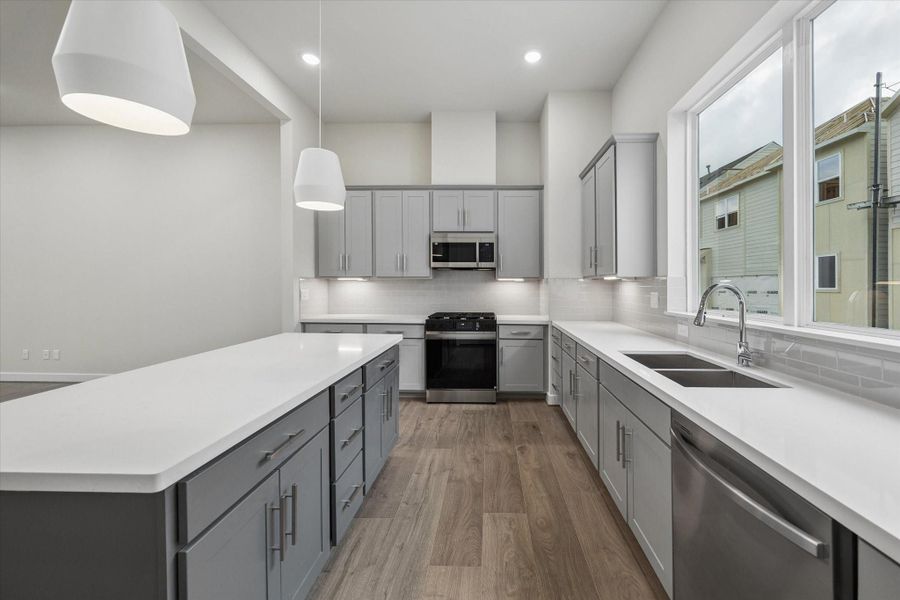 quartz countertops, shaker cabinetry, subway tile backsplash, SS Samsung Appliances.
