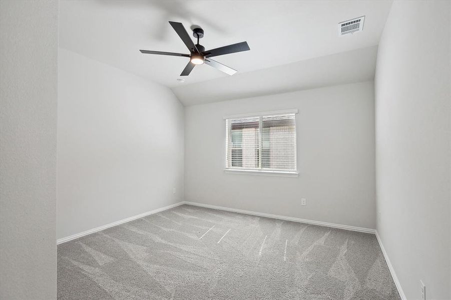 Carpeted empty room with baseboards, a ceiling fan, and lofted ceiling
