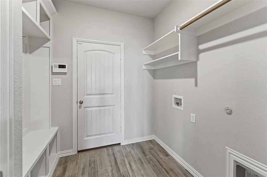 Laundry area with light wood-type flooring, hookup for a washing machine, and gas dryer hookup