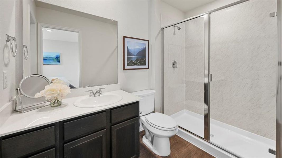 Bathroom featuring vanity, a stall shower, and dark wood-style flooring