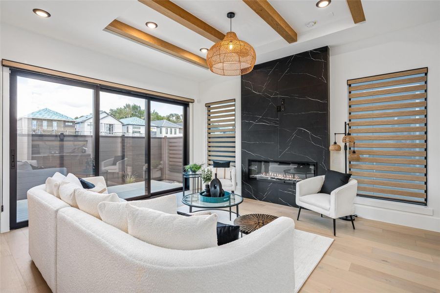 Vaulted ceilings adorned with beautiful architectural wood beams elevate the scale and elegance of the living room