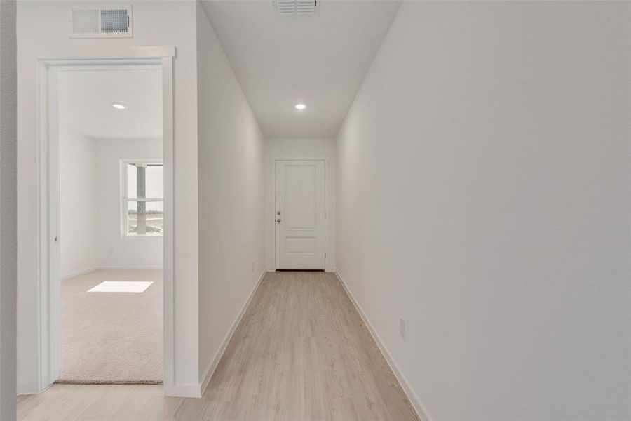 Corridor with light hardwood / wood-style flooring