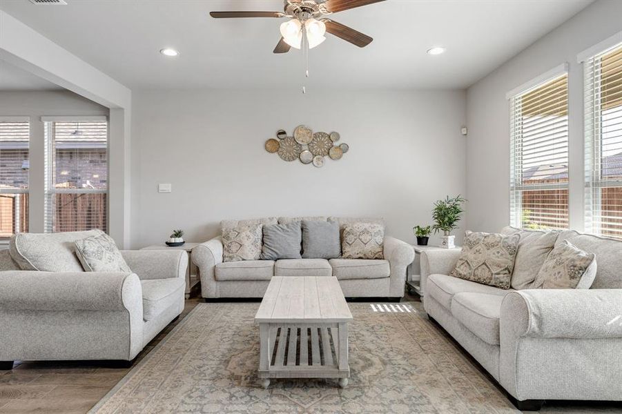 Living area featuring plenty of natural light, light wood-style floors, a ceiling fan, and recessed lighting