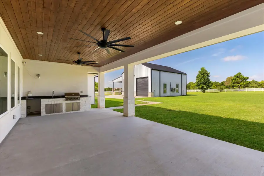Oversized covered patio with outdoor grill and sink with water. This overlooks the backyard and your can see this amazing shop with air conditioning and heat. Oversized covered patio with outdoor grill and sink with water. This overlooks the backyard and your can see this amazing shop with air conditioning and heat.
