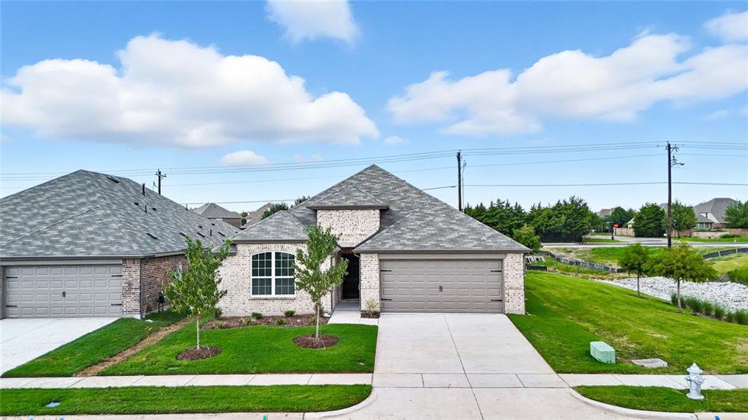 French country home with roof with shingles, driveway, and a front lawn