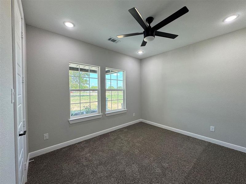 Room featuring neutral wall tones and dark carpet flooring