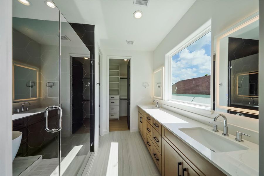 Luxurious ensuite master bath with dual vanities and a spacious walk-in closet. Luxurious ensuite master bath with dual vanities and a spacious walk-in closet.