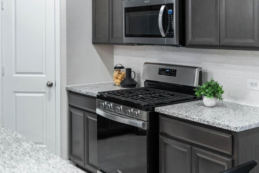 This functional kitchen is complete with essential, stylish stainless steel appliances, including a durable gas range/oven and an efficient microwave, ensuring immediate move-in readiness.