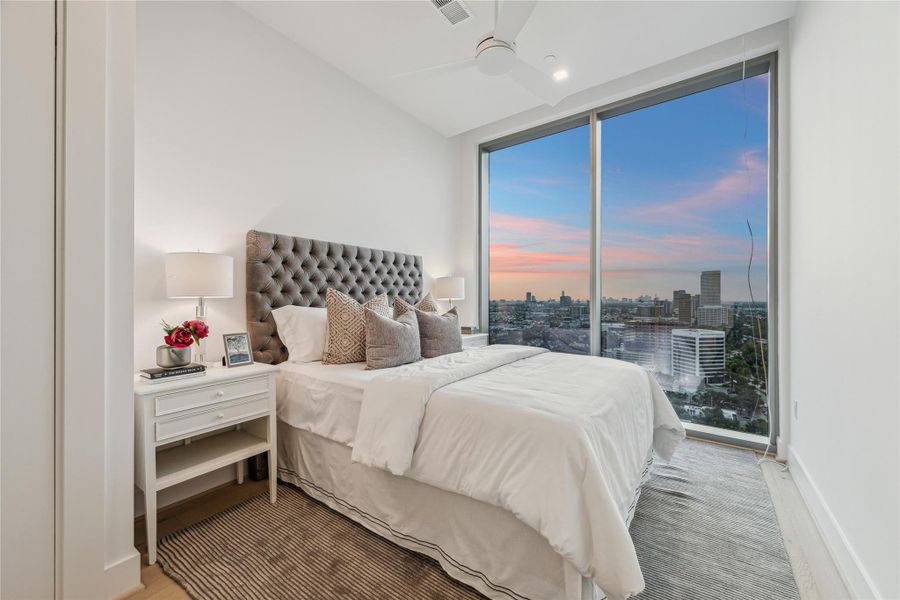 Secondary bedroom featuring floor-to-ceiling windows and custom built-out closets. Secondary bedroom featuring floor-to-ceiling windows and custom built-out closets.