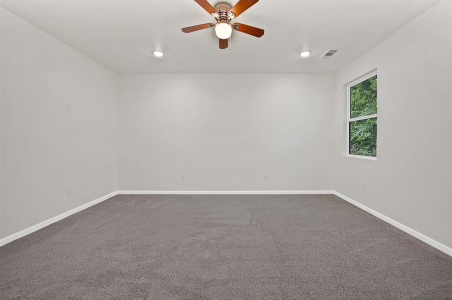 Unfurnished room featuring dark colored carpet, a ceiling fan, and recessed lighting
