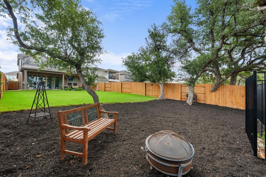 An inviting backyard oasis offers ample space for recreation and relaxation, framed by lush greenery and a sturdy privacy fence. An inviting backyard oasis offers ample space for recreation and relaxation, framed by lush greenery and a sturdy privacy fence.