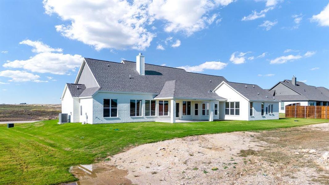 Back of house featuring a lawn, central AC, and a patio area