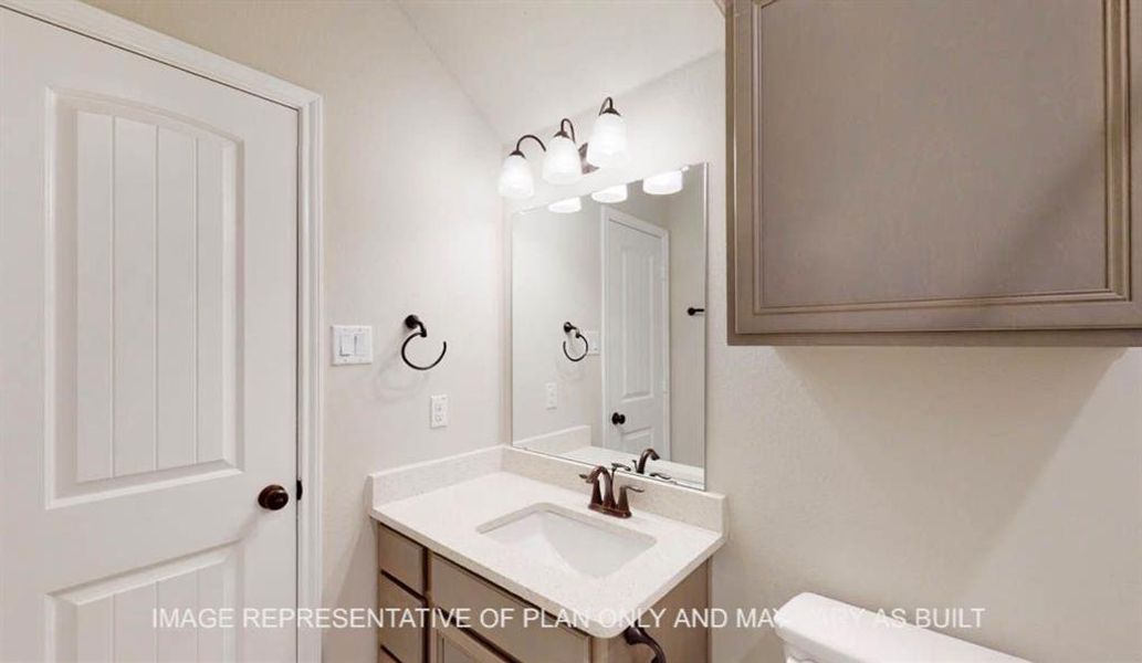 Half bathroom featuring vanity and toilet Half bathroom featuring vanity and toilet