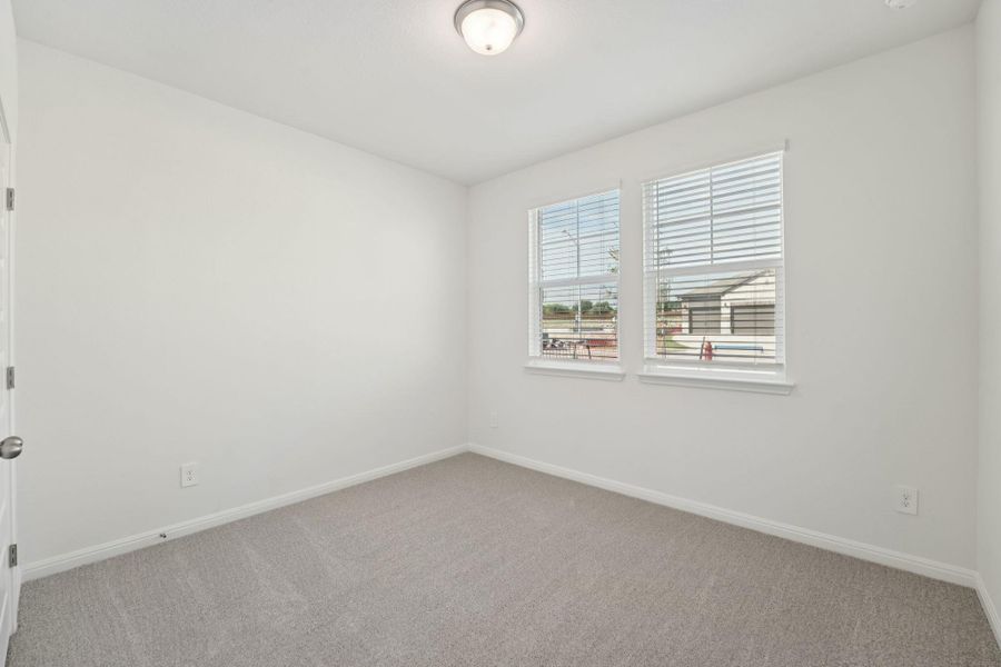 Carpeted spare room featuring baseboards