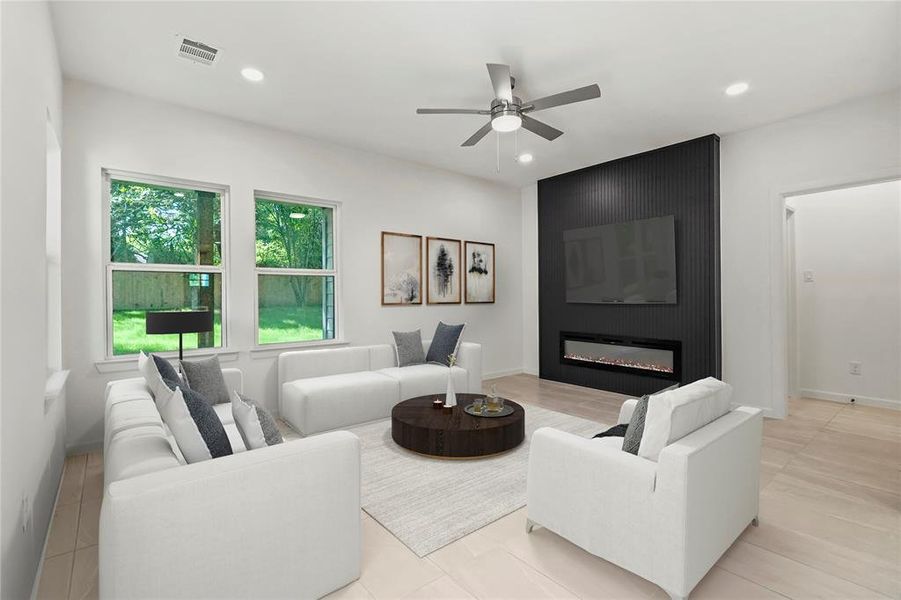Living room featuring a ceiling fan, recessed lighting, and a large fireplace