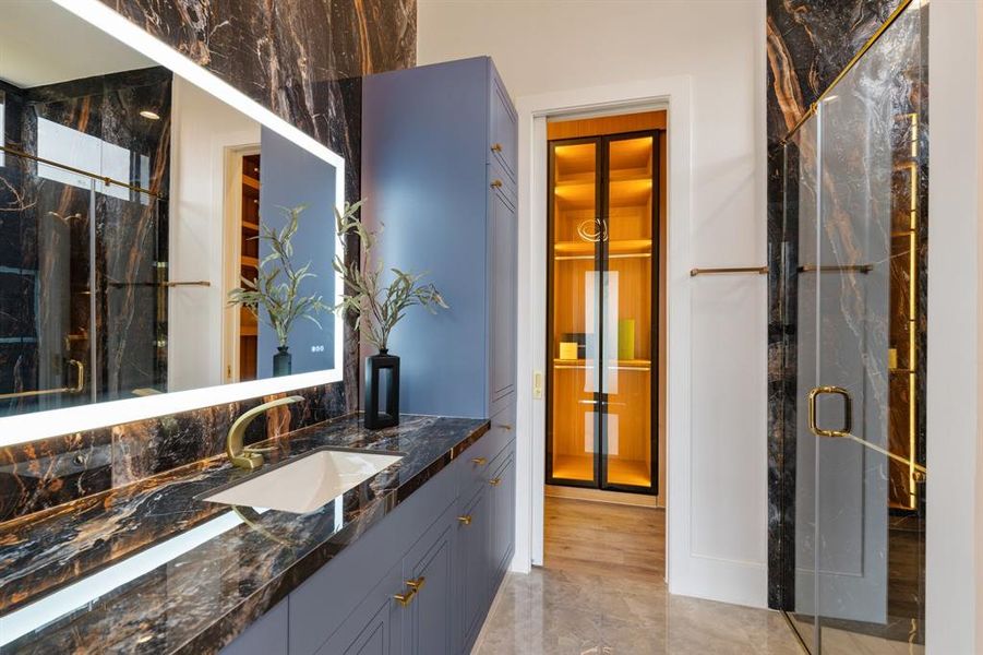 Immerse yourself in the beauty of the luxurious ensuite bathroom, boasting a gorgeous design, LED custom glass-enclosed closet, and shelving for a truly indulgent experience.