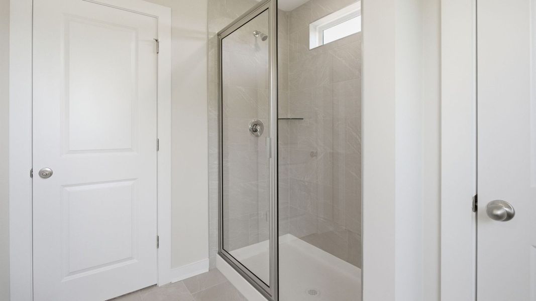 Bathroom with glass enclosed shower with bright natural light from window Bathroom with glass enclosed shower with bright natural light from window