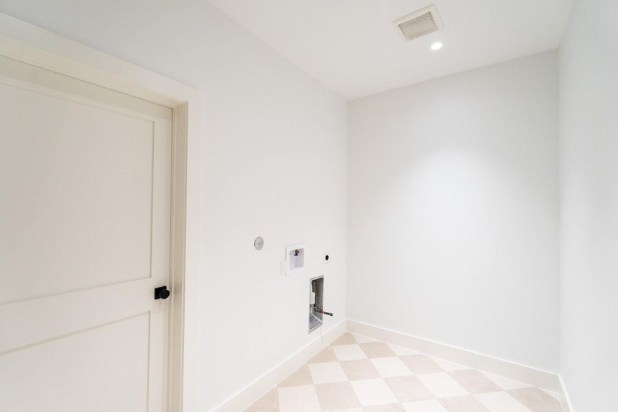 Large laundry room with access to the primary closet