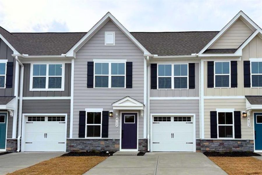 Front exterior of a new home in Lakes at Riverbend Townhomes, Navassa, NC, highlighting curb appeal (Image 1). Front exterior of a new home in Lakes at Riverbend Townhomes, Navassa, NC, highlighting curb appeal (Image 1).