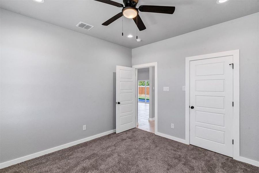 Unfurnished bedroom featuring ceiling fan and carpet floors