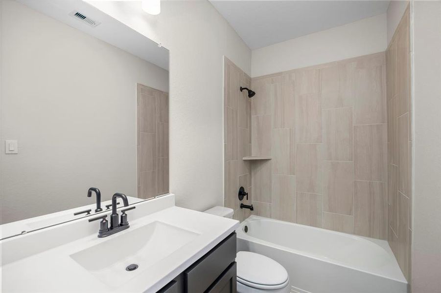 The secondary bathroom features a tiled tub/shower combination.