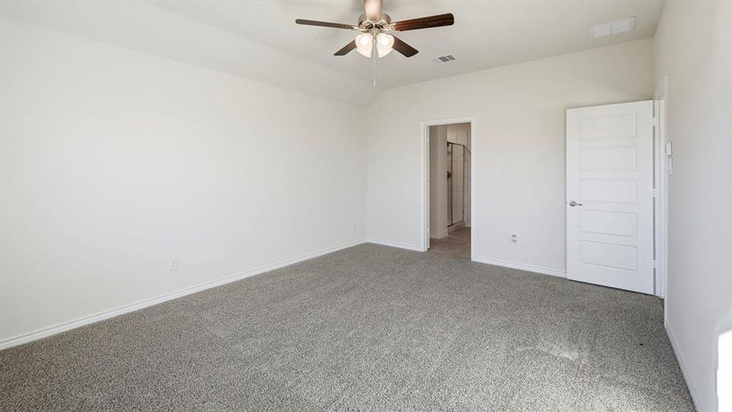 Unfurnished bedroom with carpet floors, ceiling fan, and vaulted ceiling Unfurnished bedroom with carpet floors, ceiling fan, and vaulted ceiling