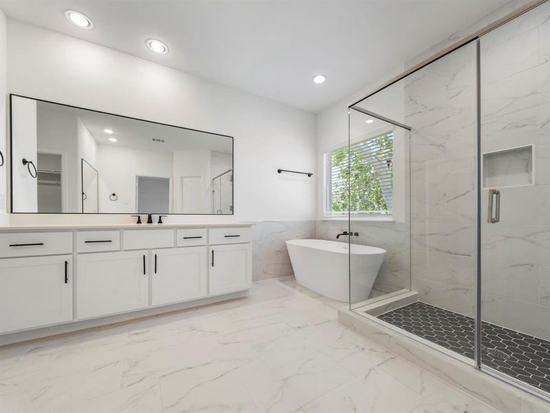 The Primary Bath is highlighted by the spacious shower and the separate soaking tub. Enjoy a nice bubble bath after a long day! (Sample photos of a completed Warwick floor plan. The image may feature alternative selections and/or upgrades.)