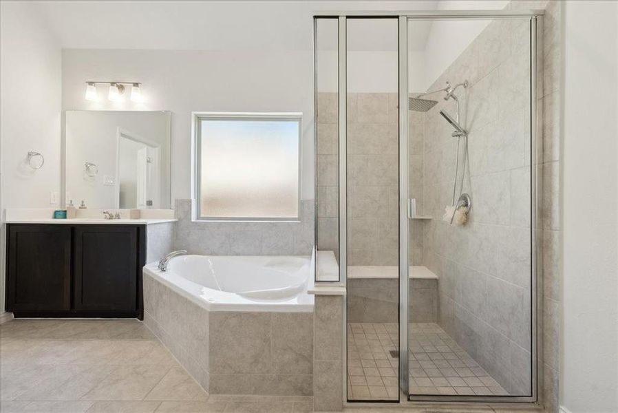 Bathroom featuring tile patterned floors, vanity, and independent shower and bath