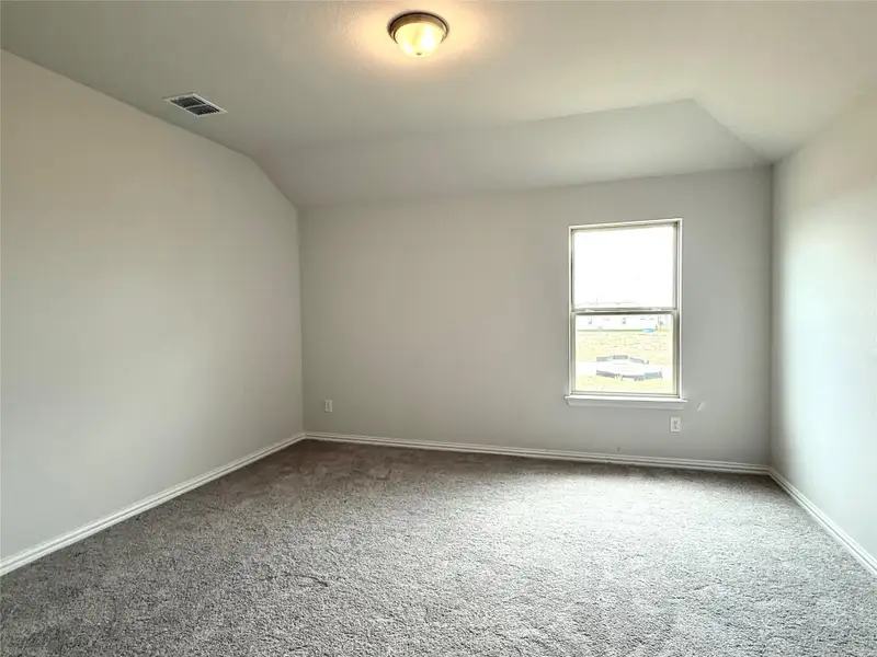 Carpeted empty room featuring lofted ceiling Carpeted empty room featuring lofted ceiling