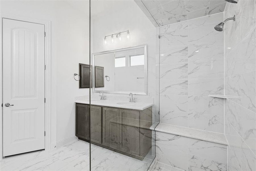 Bathroom featuring tile patterned floors, vanity, and tiled shower