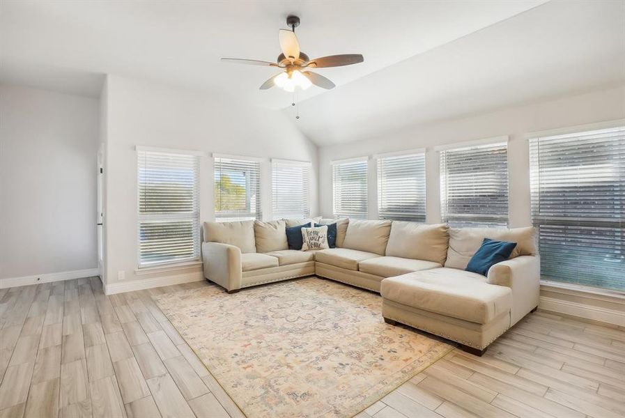 Living room with high ceiling, celing fan & lots of windows