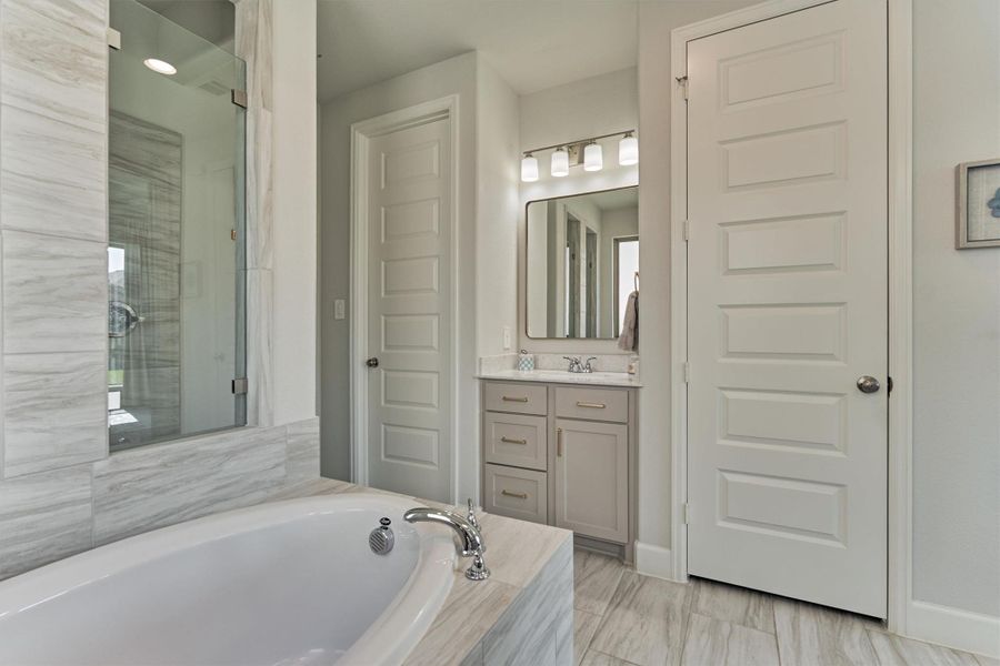 Spa-Inspired Primary bath has a generous walk-in closet offering extensive storage and organization options.