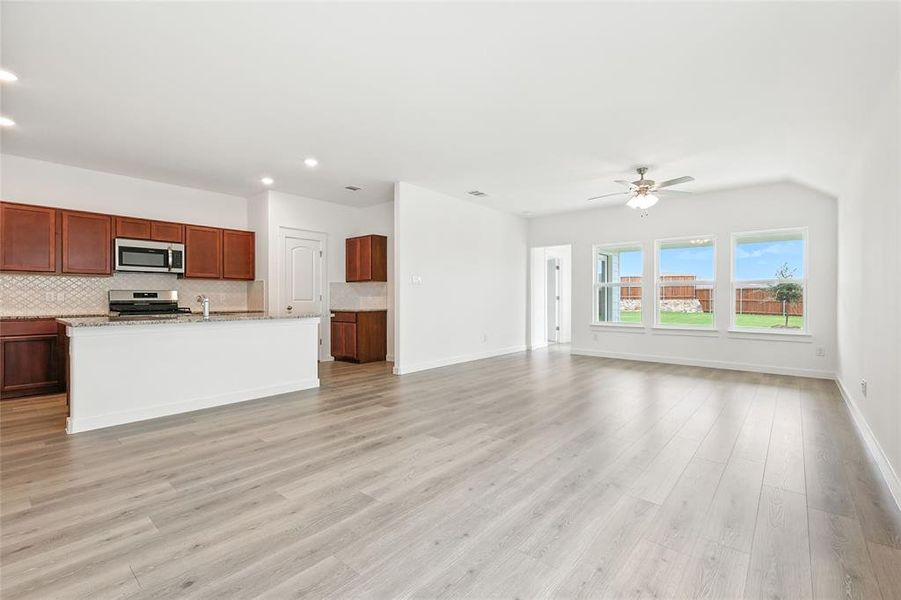 Unfurnished living room featuring light wood finished floors, a ceiling fan, and recessed lighting Unfurnished living room featuring light wood finished floors, a ceiling fan, and recessed lighting