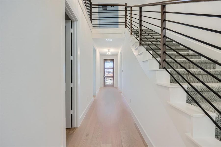 Corridor with a high ceiling and hardwood / wood-style flooring