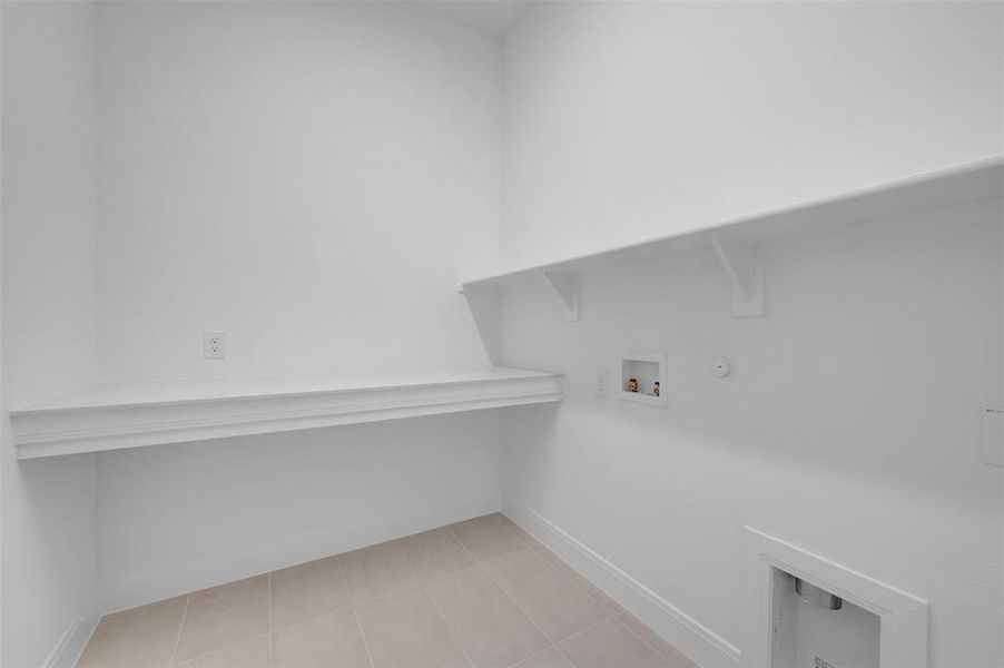 Laundry area featuring gas dryer hookup, light tile patterned flooring, and washer hookup