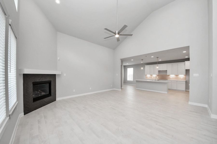 Family room flooded with natural light through the expansive windows.  The premium tile flooring adds a touch of luxury to the space, creating the perfect setting for relaxing moments and cherished gatherings with loved ones.