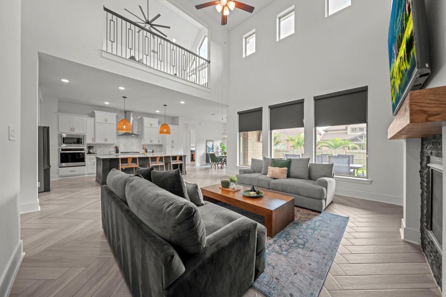 Seamless flow from the living room into the kitchen and dining areas. The balcony overlook and large windows keep the space bright and connected. Seamless flow from the living room into the kitchen and dining areas. The balcony overlook and large windows keep the space bright and connected.