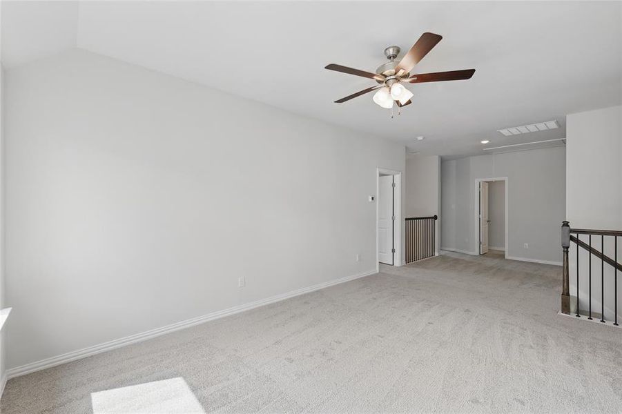 Empty room with light colored carpet and ceiling fan