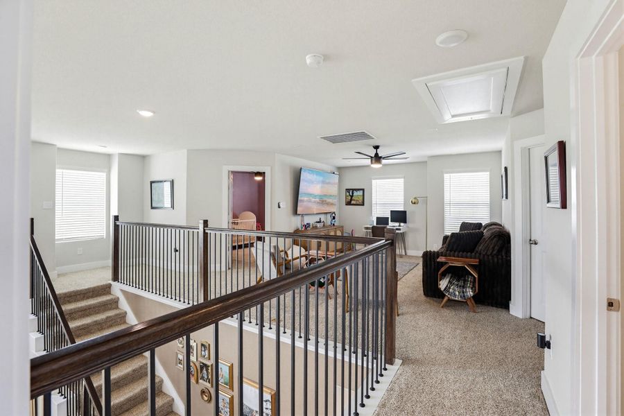 Upper level living space featuring neutral-toned carpeting and light gray wall paint