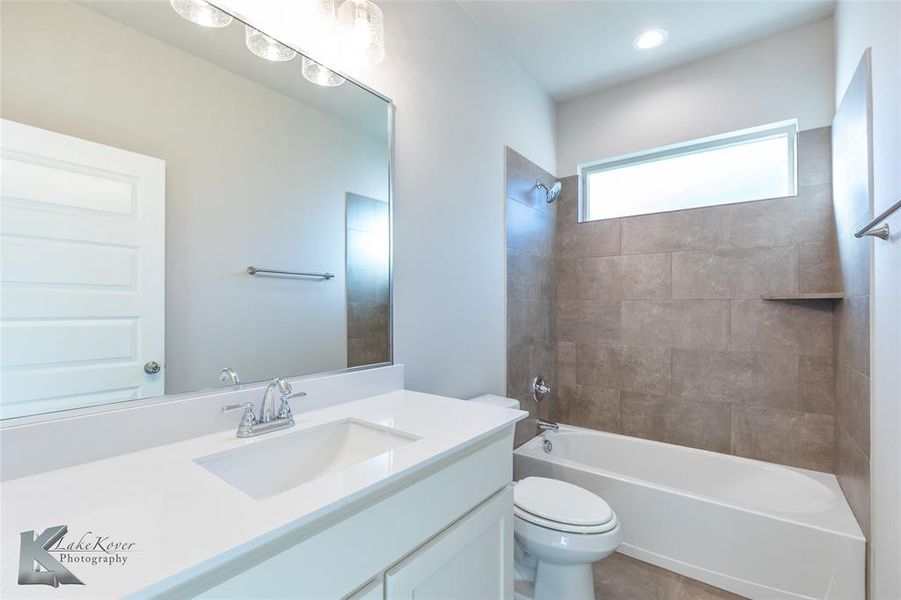Bathroom with vanity, bathing tub / shower combination, and tile patterned floors