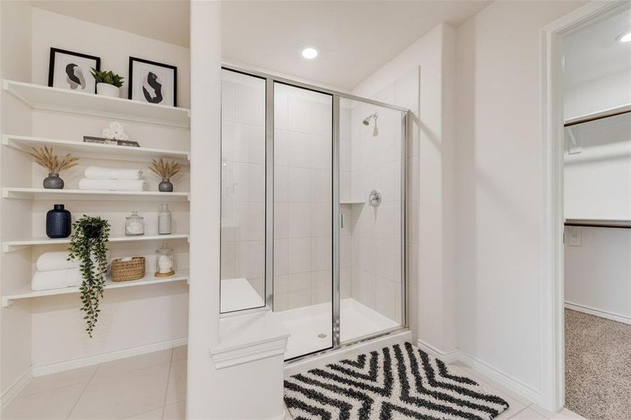 Full bath featuring a walk in closet, a stall shower, light tile patterned floors, and recessed lighting