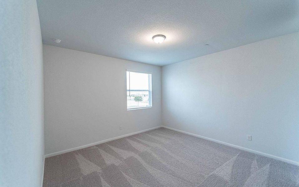 Carpeted empty room featuring baseboards