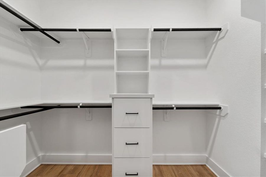 Your spacious walk in closet has additional custom cabinetry and exposed shelving for extra storage and convenience.